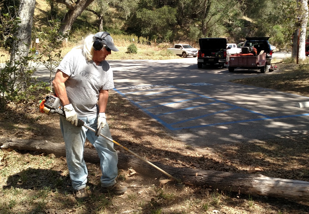 Dave weed-whacking at the trail head!